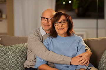 Image showing happy senior couple hugging on sofa at home