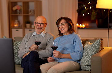 Image showing happy senior couple drink red wine and watch tv