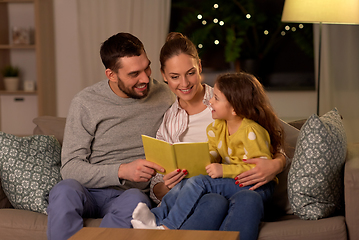 Image showing happy family reading book at home at night