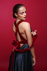 Image showing beautiful woman in silk dress with red bow