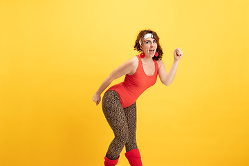 Image showing Young caucasian plus size female model\'s training on yellow background