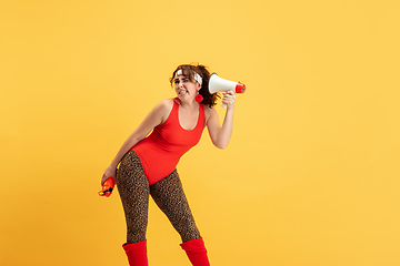 Image showing Young caucasian plus size female model\'s training on yellow background