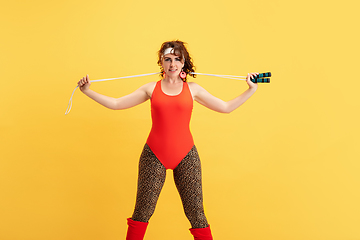 Image showing Young caucasian plus size female model\'s training on yellow background