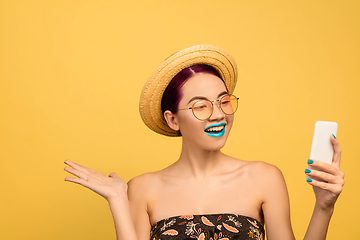 Image showing Portrait of beautiful young woman with bright make-up isolated on yellow studio background