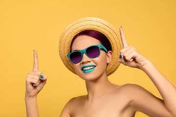 Image showing Portrait of beautiful young woman with bright make-up isolated on yellow studio background