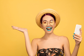 Image showing Portrait of beautiful young woman with bright make-up isolated on yellow studio background