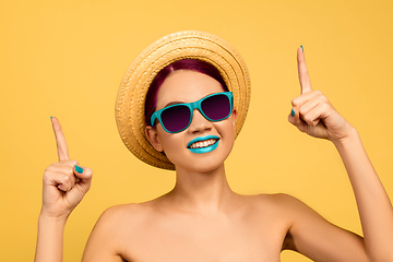 Image showing Portrait of beautiful young woman with bright make-up isolated on yellow studio background