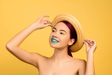 Image showing Portrait of beautiful young woman with bright make-up isolated on yellow studio background