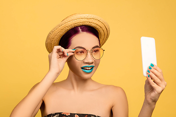 Image showing Portrait of beautiful young woman with bright make-up isolated on yellow studio background