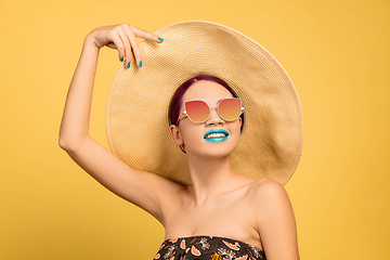 Image showing Portrait of beautiful young woman with bright make-up isolated on yellow studio background