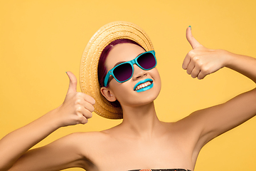 Image showing Portrait of beautiful young woman with bright make-up isolated on yellow studio background