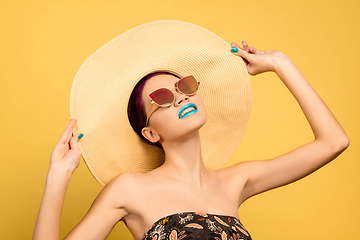 Image showing Portrait of beautiful young woman with bright make-up isolated on yellow studio background