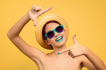 Image showing Portrait of beautiful young woman with bright make-up isolated on yellow studio background