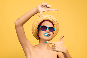 Image showing Portrait of beautiful young woman with bright make-up isolated on yellow studio background