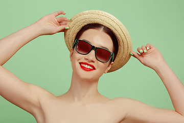 Image showing Portrait of beautiful young woman with bright make-up isolated on green studio background