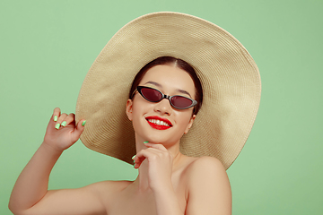 Image showing Portrait of beautiful young woman with bright make-up isolated on green studio background