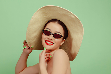 Image showing Portrait of beautiful young woman with bright make-up isolated on green studio background