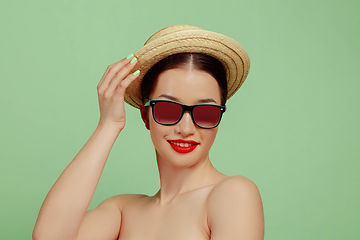 Image showing Portrait of beautiful young woman with bright make-up isolated on green studio background