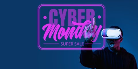 Image showing Half-length close up portrait of young man in neon light with cyber monday lettering