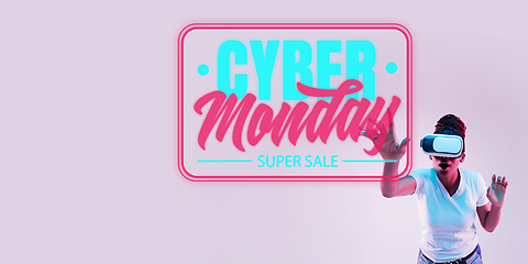 Image showing Half-length close up portrait of young woman in neon light with cyber monday lettering