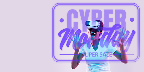 Image showing Half-length close up portrait of young woman in neon light with cyber monday lettering