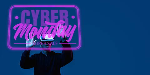 Image showing Half-length close up portrait of young man in neon light with cyber monday lettering