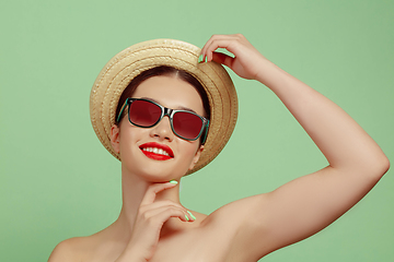 Image showing Portrait of beautiful young woman with bright make-up isolated on green studio background