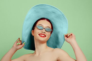 Image showing Portrait of beautiful young woman with bright make-up isolated on green studio background