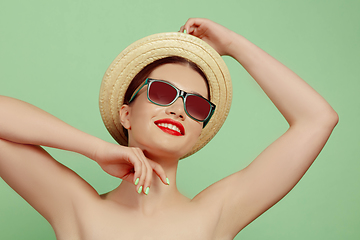 Image showing Portrait of beautiful young woman with bright make-up isolated on green studio background