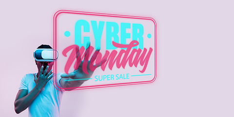 Image showing Half-length close up portrait of young man in neon light with cyber monday lettering