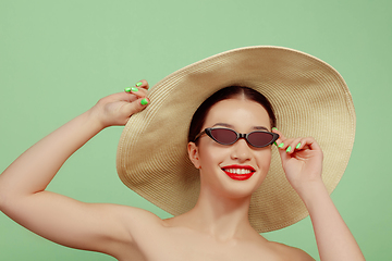 Image showing Portrait of beautiful young woman with bright make-up isolated on green studio background