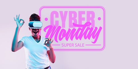 Image showing Half-length close up portrait of young woman in neon light with cyber monday lettering