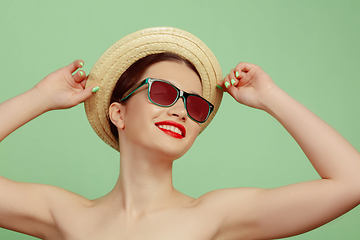 Image showing Portrait of beautiful young woman with bright make-up isolated on green studio background