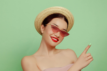 Image showing Portrait of beautiful young woman with bright make-up isolated on green studio background