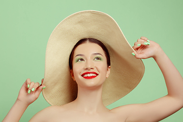 Image showing Portrait of beautiful young woman with bright make-up isolated on green studio background