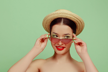 Image showing Portrait of beautiful young woman with bright make-up isolated on green studio background