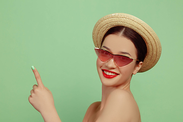 Image showing Portrait of beautiful young woman with bright make-up isolated on green studio background