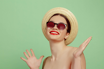 Image showing Portrait of beautiful young woman with bright make-up isolated on green studio background