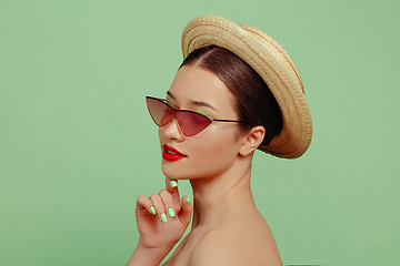 Image showing Portrait of beautiful young woman with bright make-up isolated on green studio background