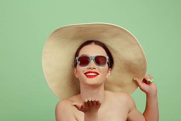 Image showing Portrait of beautiful young woman with bright make-up isolated on green studio background