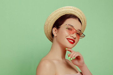 Image showing Portrait of beautiful young woman with bright make-up isolated on green studio background