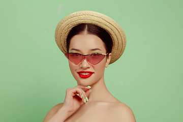 Image showing Portrait of beautiful young woman with bright make-up isolated on green studio background