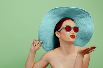 Image showing Portrait of beautiful young woman with bright make-up isolated on green studio background