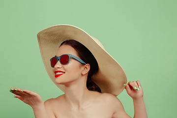 Image showing Portrait of beautiful young woman with bright make-up isolated on green studio background