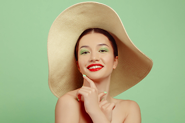 Image showing Portrait of beautiful young woman with bright make-up isolated on green studio background