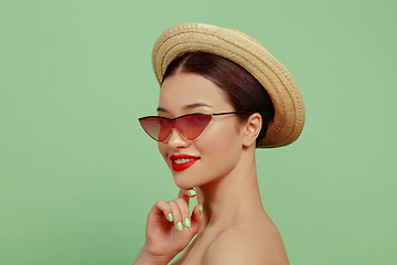 Image showing Portrait of beautiful young woman with bright make-up isolated on green studio background