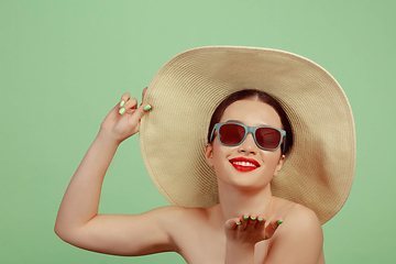 Image showing Portrait of beautiful young woman with bright make-up isolated on green studio background