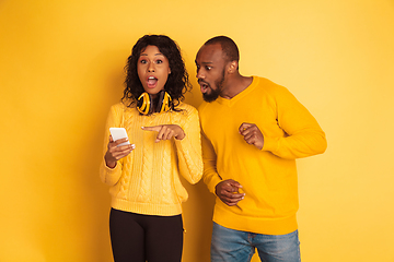 Image showing Young emotional african-american man and woman on yellow background