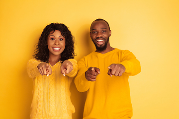 Image showing Young emotional african-american man and woman on yellow background