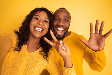 Image showing Young emotional african-american man and woman on yellow background